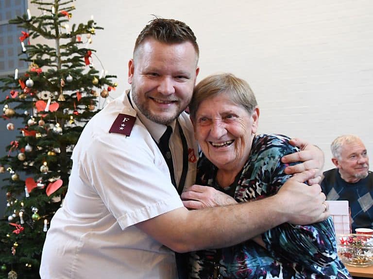 Når julehjælpen uddeles, er Else Bergholm fortsat frivillig hjælper – og får her et julekram af korpsleder, kaptajn Jan Marseille. (Foto: Levi Giversen).